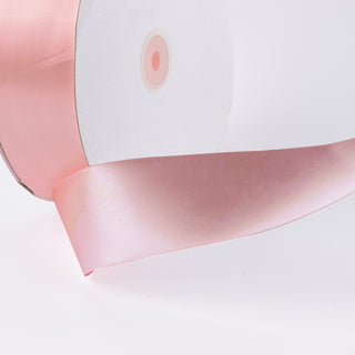Pink satin ribbon roll on white background with soft sheen