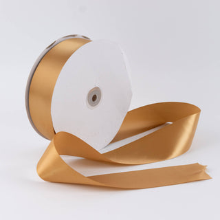 Gold satin ribbon spool on white background