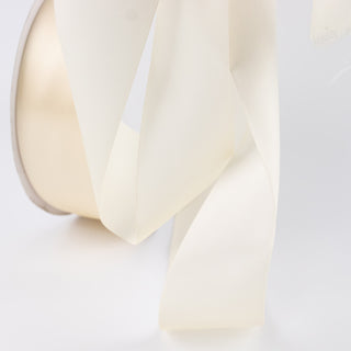 Cream satin ribbon bow on a white background