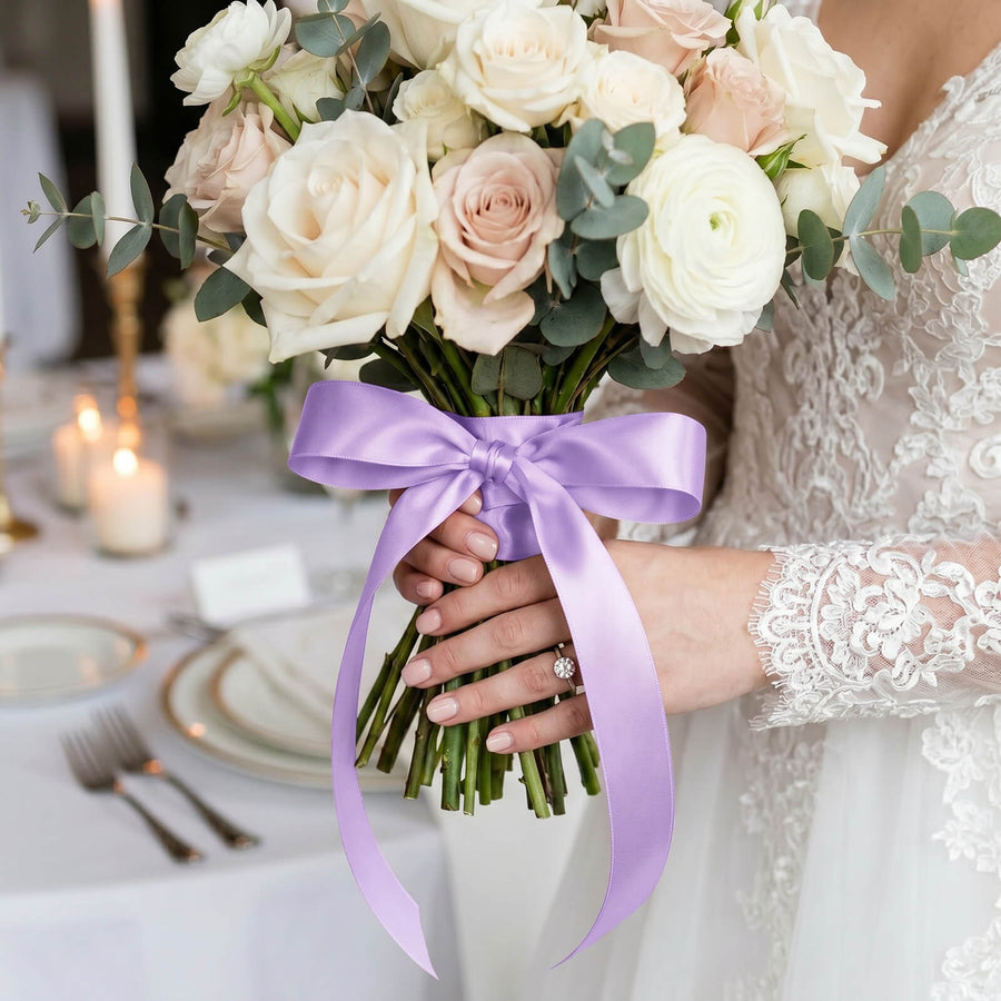 Bride holding pastel rose bouquet with lavender ribbon at wedding ceremony