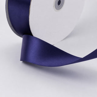 Purple satin ribbon spool on white background