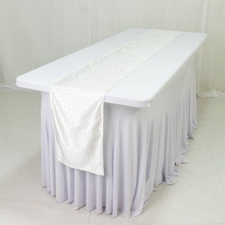 White table with a sparkling runner on a light gray tablecloth