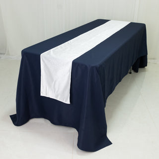 Navy tablecloth with white runner and embellishments on a dining table