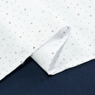 White fabric with silver embellishments, showcasing texture and detail.