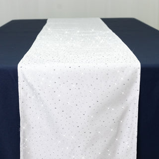 Sparkling white table runner with silver accents on a blue table.