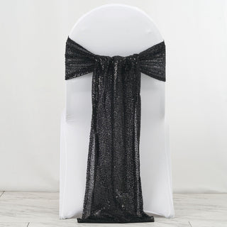Black sequin chair cover with bow detail on a white chair