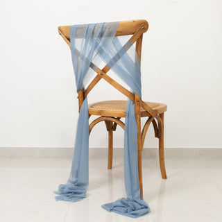 Wooden chair draped with blue fabric on a plain background