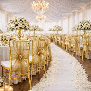 Elegant wedding reception setup with gold chairs and floral centerpieces.