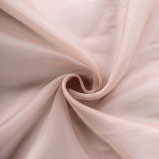 Soft pink fabric draped in swirling folds, showcasing delicate texture. #whtbkgd