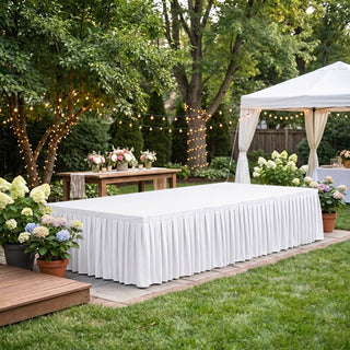 Elegant outdoor wedding reception setup with white tent, flowers, and string lights