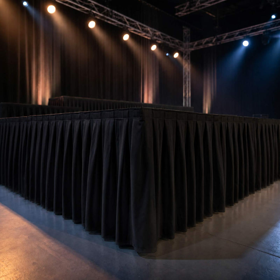 Empty stage with black drapes and dramatic spotlights at an event venue