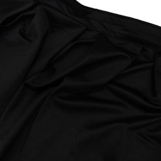 Black ribbed fabric texture with soft folds and draped shadows