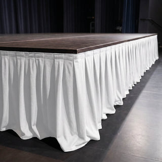 Stage platform with white draped skirt in an event venue