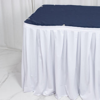 White round table with navy tablecloth and floor-length drape cover