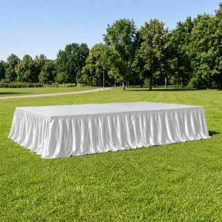 White stage skirt drape on outdoor event platform in park setting