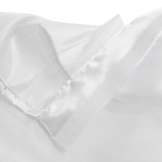 Close-up of white satin fabric with soft folds and stitching