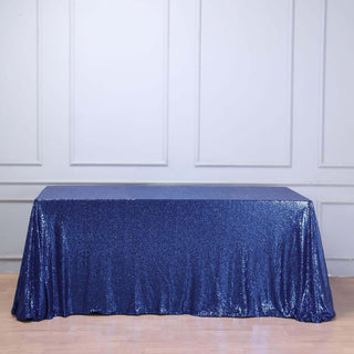 Blue sequin tablecloth draped over a table in a studio setting.