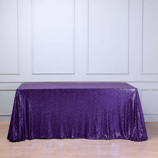 Purple sequin tablecloth draping a table in a studio setting.