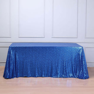 Blue sequin tablecloth draped over a table, sparkling design.