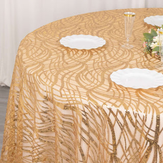 Gold patterned tablecloth on a round table with white plates and floral centerpiece.