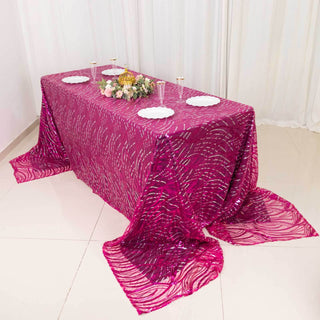 Elegant pink tablecloth with intricate design on a dining table.