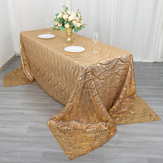 Elegant gold tablecloth on a dining table with floral centerpiece and plates.