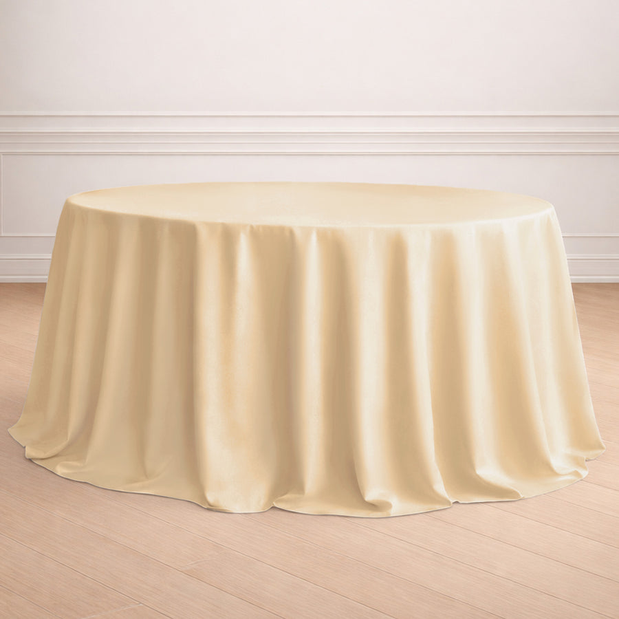 Round ivory tablecloth draping over a circular table in a staged setting.