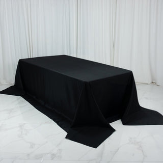 Black tablecloth draped over a table on a marble floor.