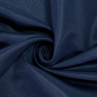 Navy blue fabric with a smooth texture, elegantly twisted in a swirl pattern. #whtbkgd