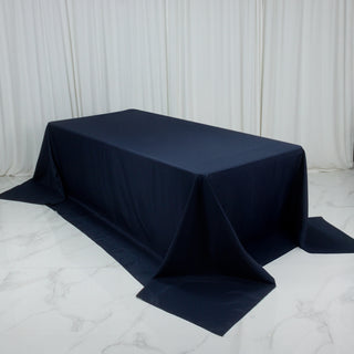 Navy blue tablecloth draped over a rectangular table on a marble surface.