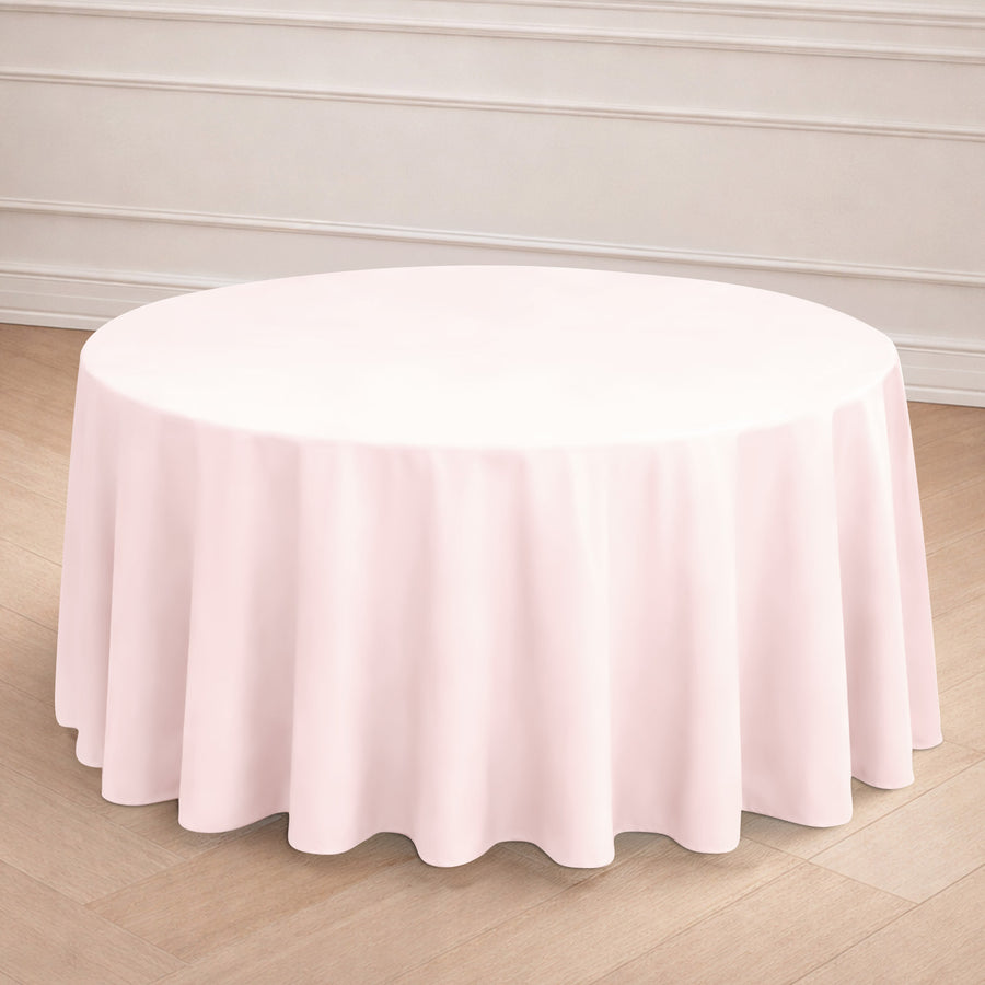 Round pink tablecloth draped over a table in a staged setting.