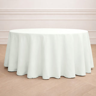 Round white tablecloth draped over a round table in a minimalistic setting.