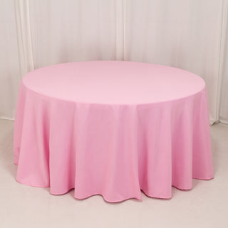 Round pink tablecloth draped elegantly over a round table.