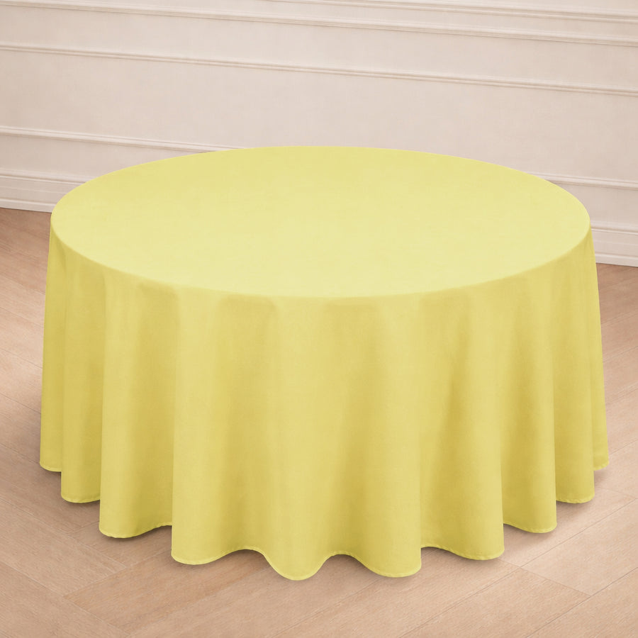 Yellow round tablecloth on a wooden floor in a bright setting.