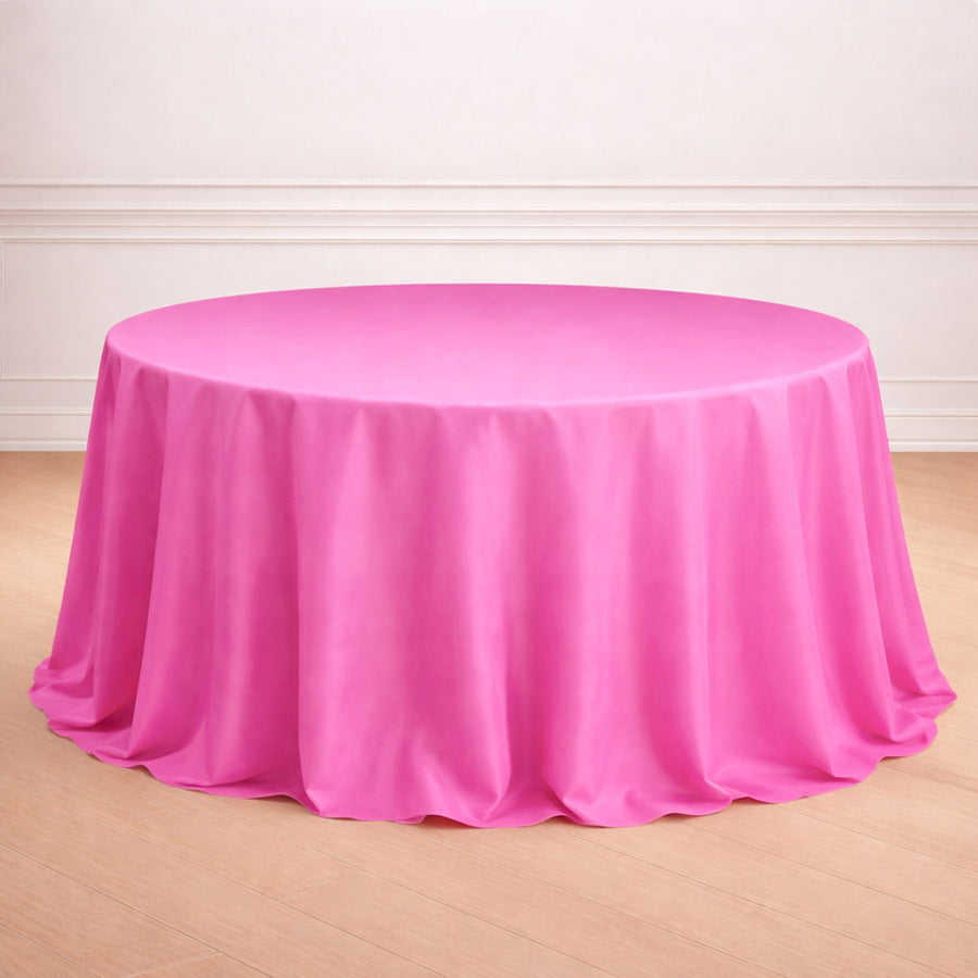 Round pink tablecloth on a wooden floor.