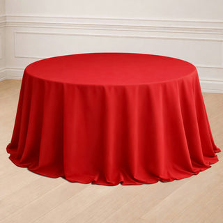 Red round tablecloth draped elegantly over a table in a bright setting.
