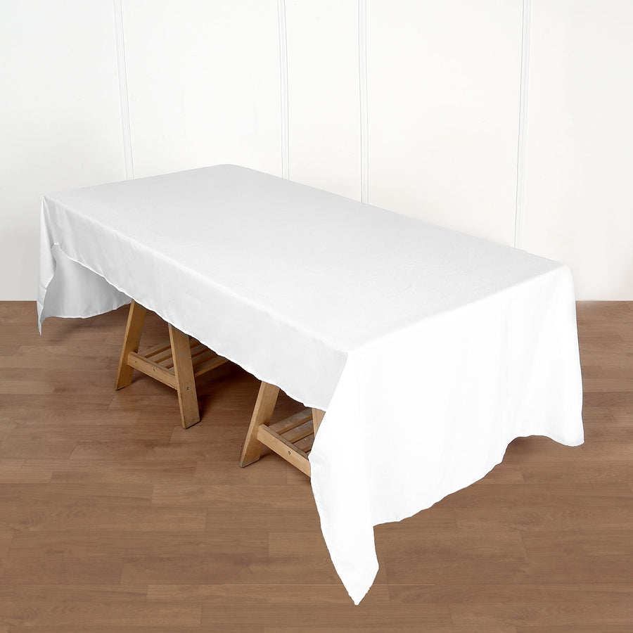 White tablecloth draped over a wooden table on a plain background.