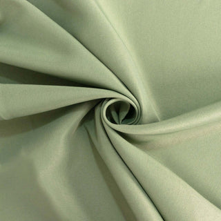 Light green fabric in a swirl pattern showcasing its texture and drape.