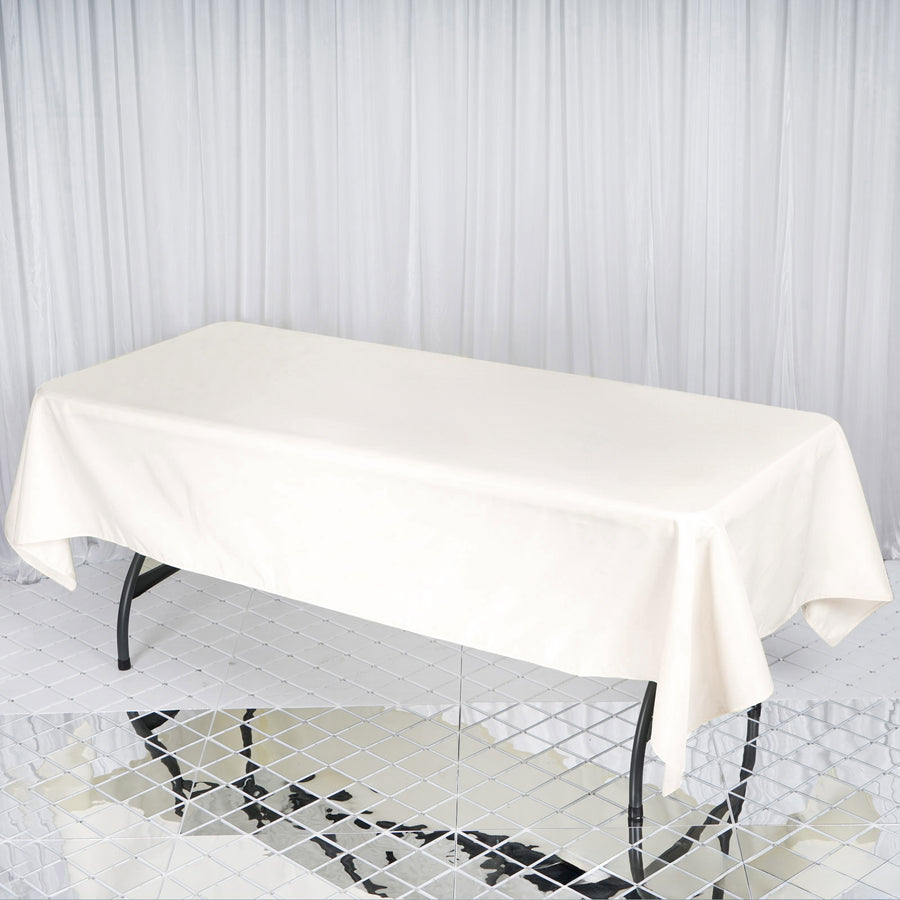 Cream tablecloth draped over a table on a reflective surface.