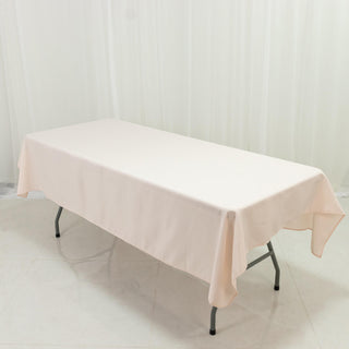 Beige tablecloth draped over a folding table in a studio setting.