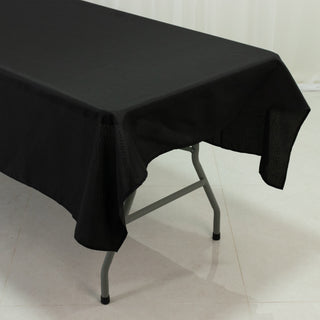 Black tablecloth draped over a folding table in a studio setting.