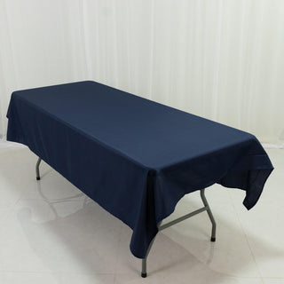 Navy tablecloth draped over a folding table on a plain backdrop.