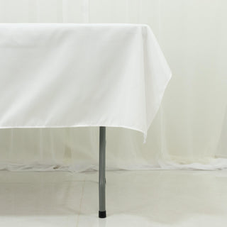 White tablecloth draped over a table leg in a clean, minimal setting.