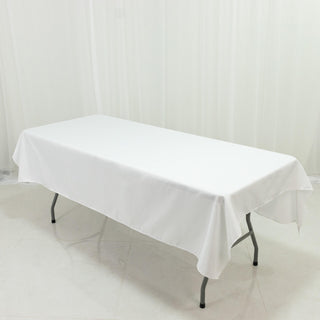 White folding table with a tablecloth on a plain background