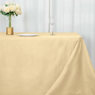 Beige tablecloth draped elegantly over a table with a vase and wine glass.