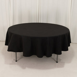 Round black tablecloth on a round table with a smooth drape.