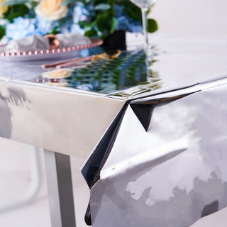 Shiny silver tablecloth draped over a table with floral centerpiece.