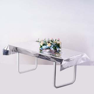 Silver table cover with floral centerpiece on a minimalist table setting.