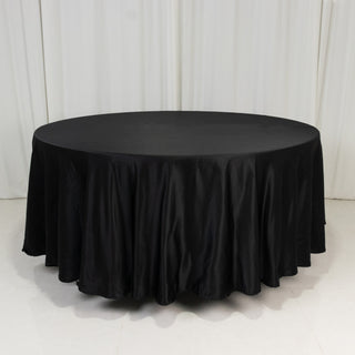 Round black tablecloth with elegant draping for events and decor.
