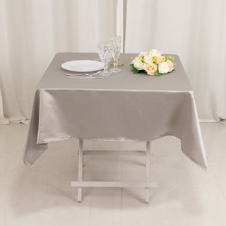 Elegant silver tablecloth with dinnerware and floral arrangement
